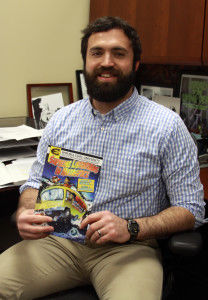 Matt Upson, assistant professor of reference and Instruction, holds his comic &#8220;Supreme Librarians in Metaspace.&#8221; Upton creates comics that encourage library use.Lingzi Su/The Bulletin