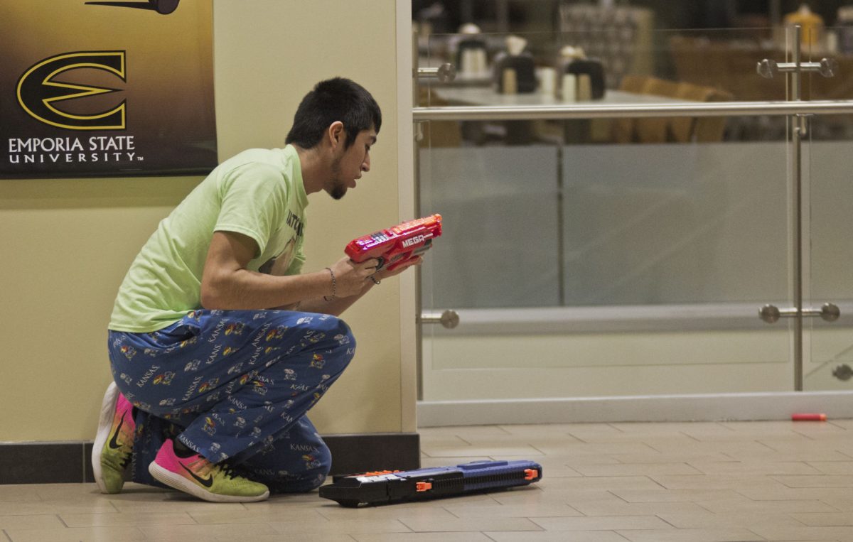 Rene Rodriguez, sophomore marketing major and Nerf Nation member, hides above a staircase Sunday in the Memorial Union during a capture the flag Nerf gun war. Nerf Nation has to have all guns with an orange tip on campus once the conceal carry law takes place.