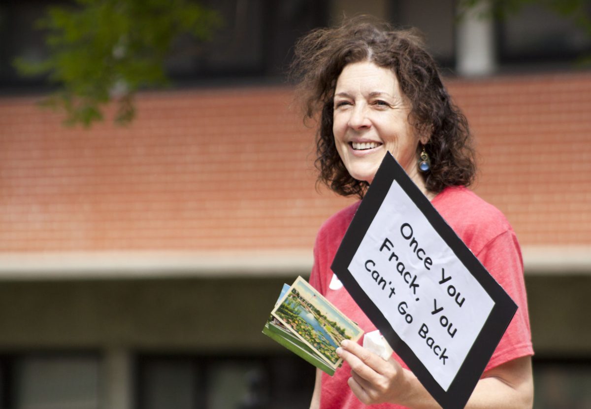 Cindy Hoedel passes out pre-stamped and pre-labeled postcards on Tuesday in the union square for students to express and mail their concerns about fracking in Morris County to the Kansas Corporation Commission. The Emporia State Green Party held the protest to raise awareness and stop Quail Oil and Gas, LC from injecting a disposal well.