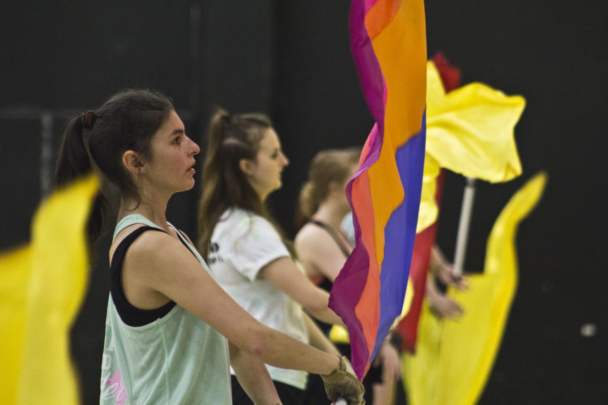 Alaina Lopez, a future Emporia State student, practices with other attendees at the colorguard's first clinic last Saturday in gym D of HPER. Colorguard is a part of the marching band that does not require a try out, but does require students be enrolled in MU245 and attend band camp and practices.