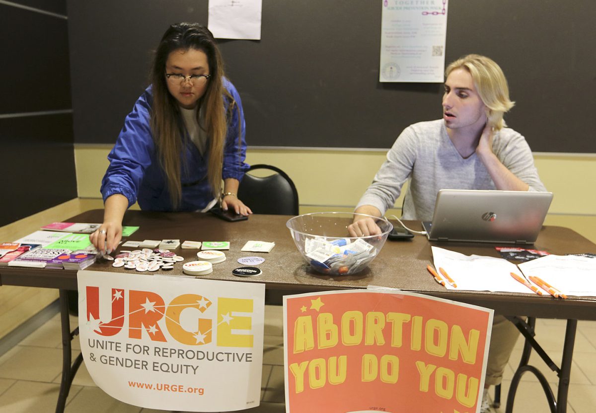 Thuong Tran, co-president of Unite for Reproductive and Gender Equity and junior painting and printmaking major, and Cale Bolen, junior political science major, table for the Sextober Slam event yesterday in the Memorial Union. The event, which is held by URGE, will be at 7-8:30 p.m. next Tuesday in the CSI lounge to celebrate LGBTQ awareness week and sex positivity.