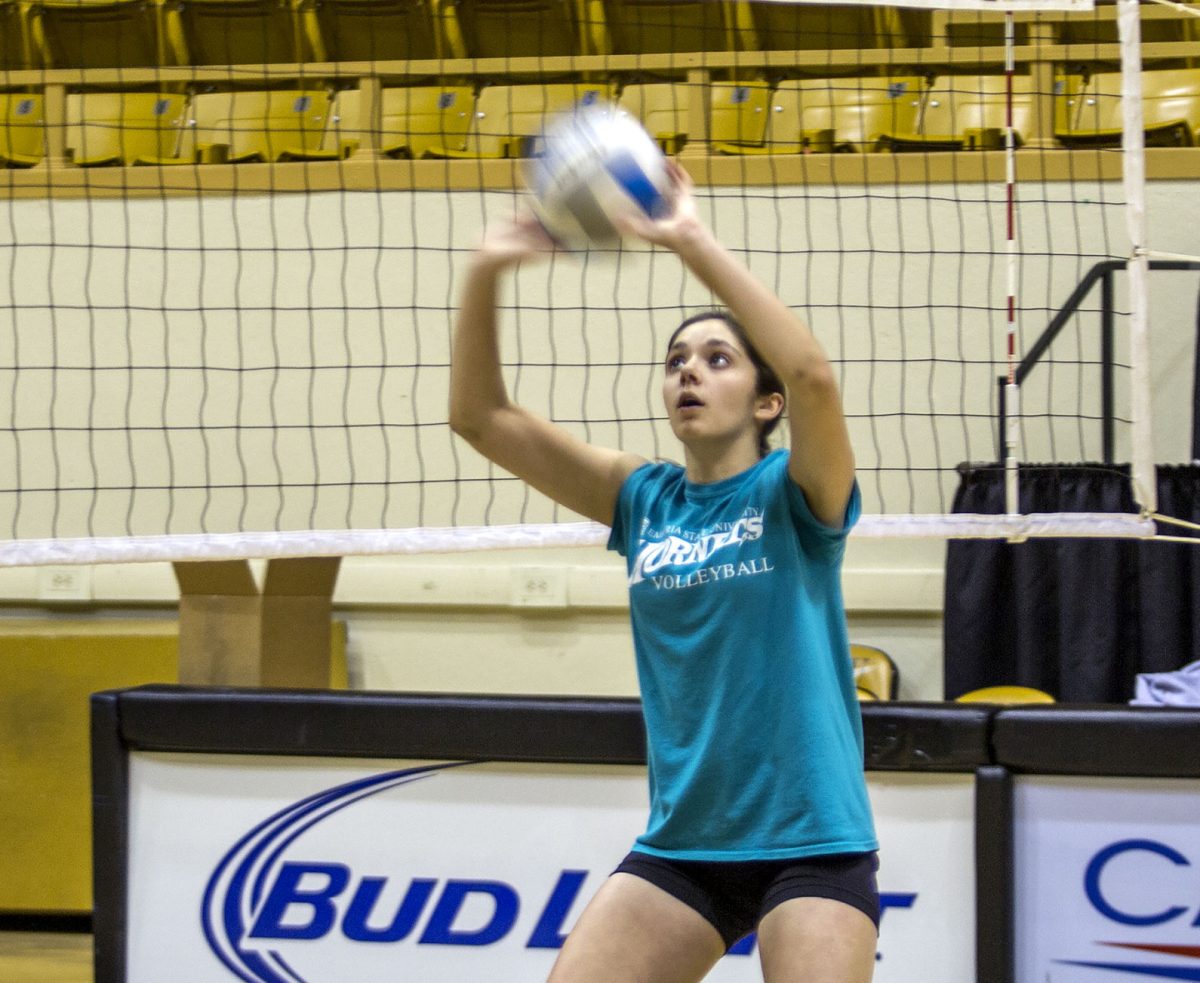 Emma Dixon, sophomore setter, practices setting Monday in the William Allen White Auditorium. Dixon started playing volleyball at the YMCA in Wichita, Kansas.