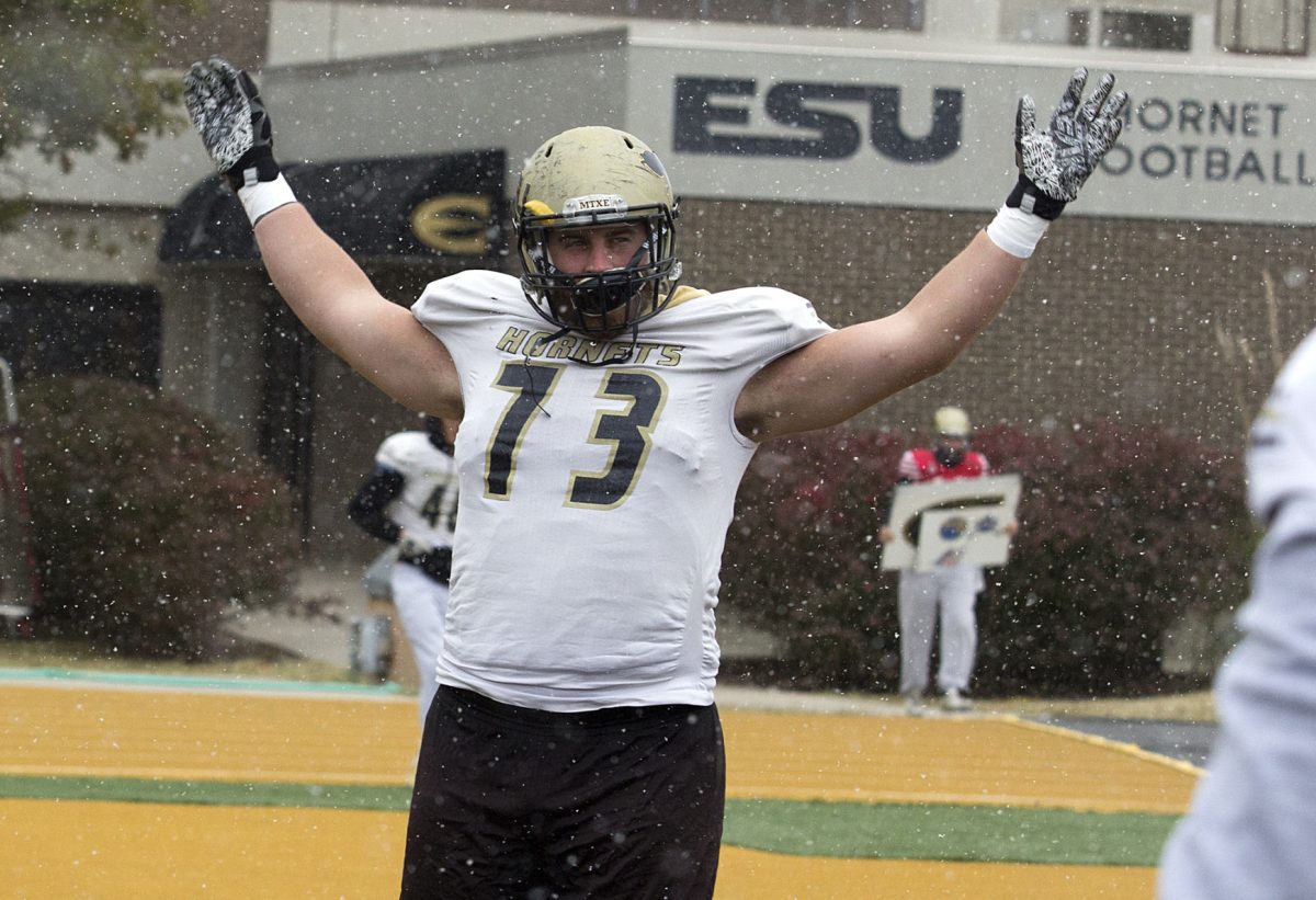 Thomas O&#8217;Grady, senior offensive lineman and a team captain, stretches Tuesday on Jones Field during a snowy practice. O&#8217;Grady transferred to Butler Community College in hopes of being recruited to a Division I school, but ultimately decided to transfer back to Emporia in 2015.