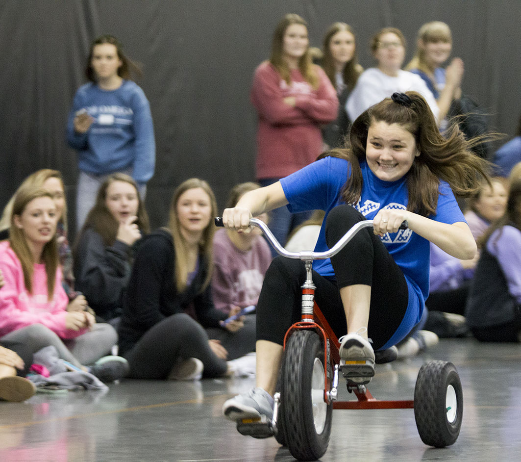 Peyton Gould, sophomore accounting major, races on a tricycle during the homecoming tricycle race event last Thursday in the student rec center.