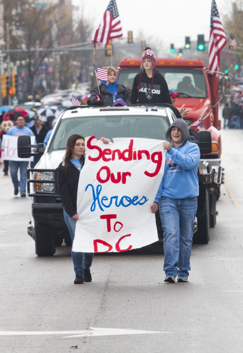 Children in the parade hold signs to give tribute to lost soldiers.