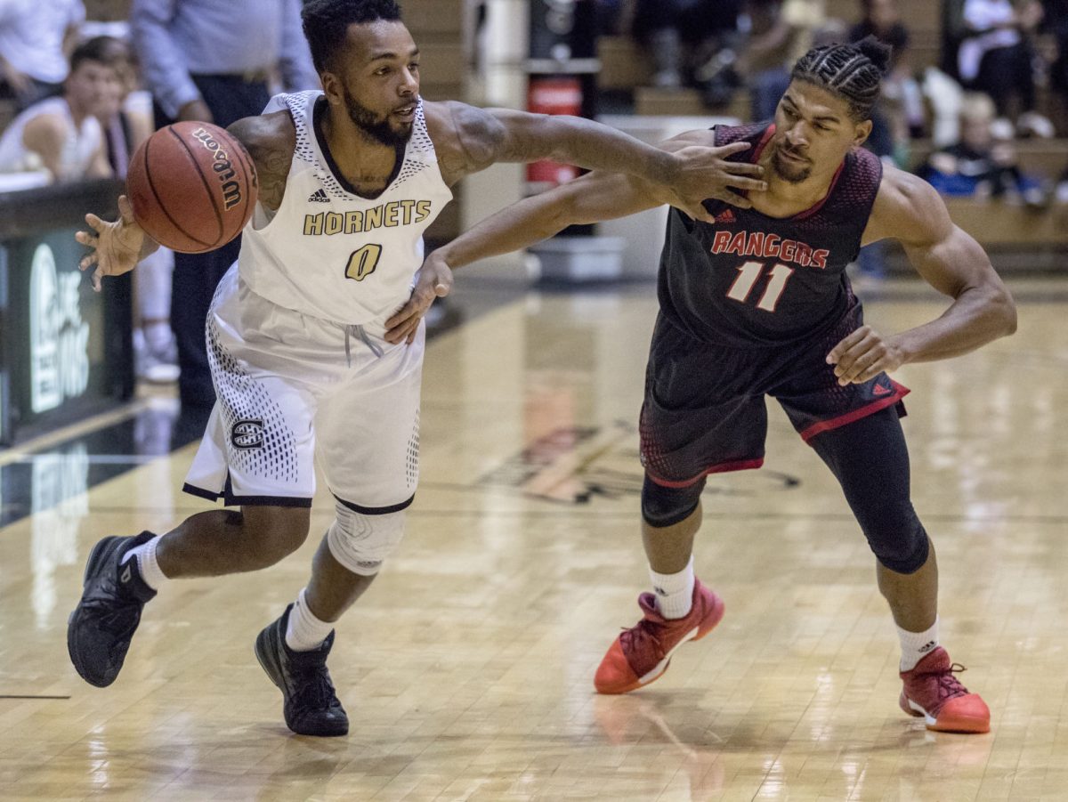 Brian Morton, senior guard, blocks a player from Northwestern Oklahoma State while running the ball down the court during last Wednesday&#8217;s game at White Auditorium. Hornets lost 71-72 against the Rangers.
