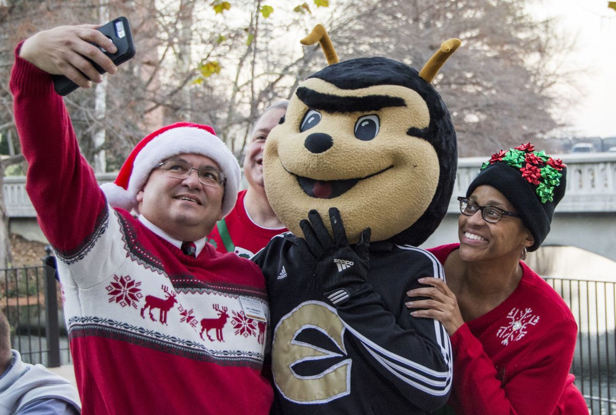 Jose Feliciano Jr. , director of alumni relations, and Michelle Hammond, dean of university libraries and archives, take a picture with Corky during Mingle and Jingle.
