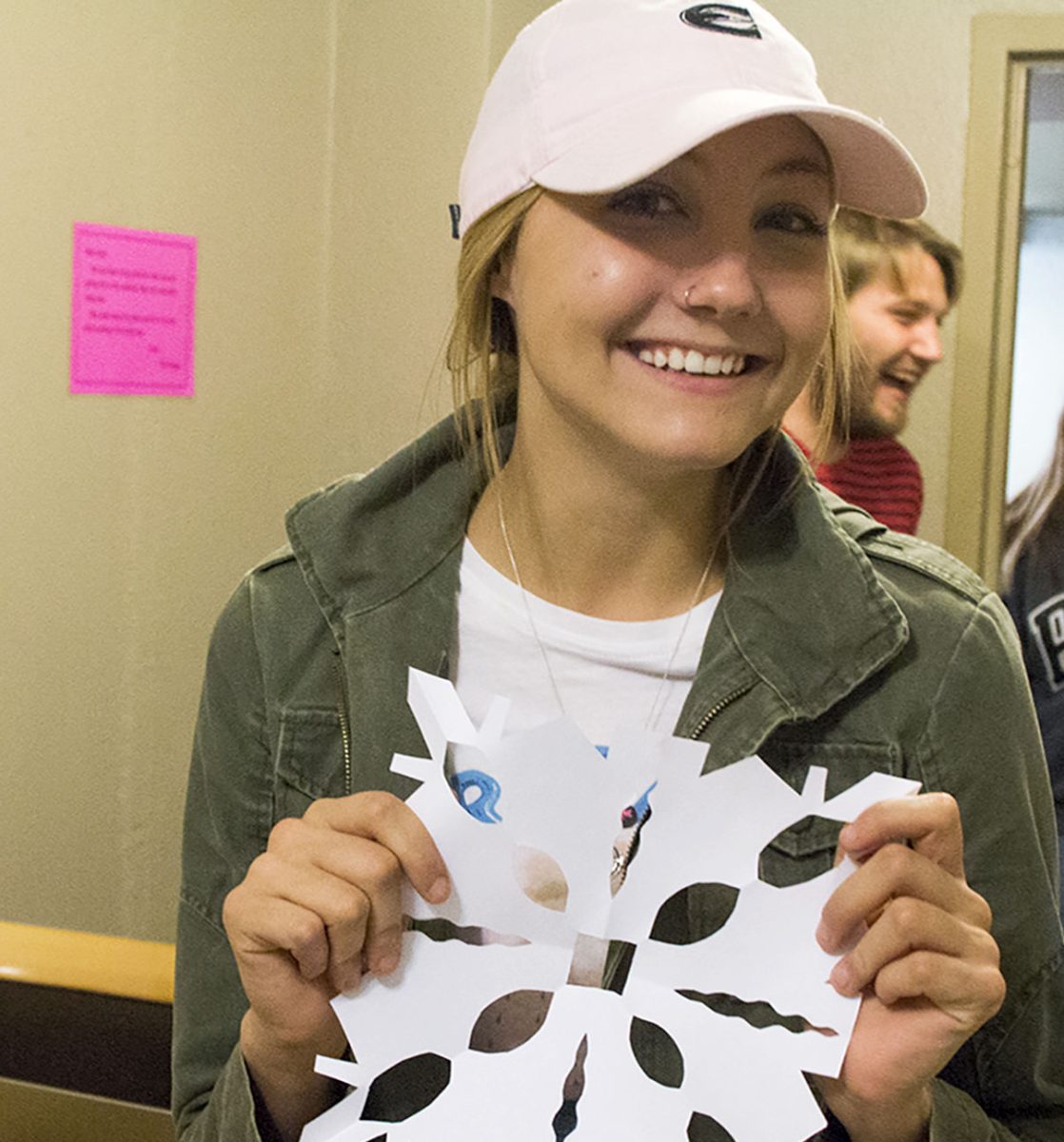 Ruth Daniel, freshman elementary education major, displays her paper snowflake yesterday in Morse.