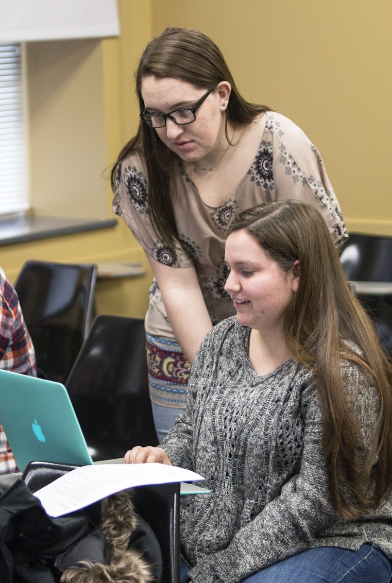 Katelyn Dorrell, graduate student and creative writing GTA, helps Margaret Clark, sophomore nursing major, with an assignment during class Tuesday in Plumb Hall. Dorrell created her own press, SlothHead Press, which opened last October and can be found at slothheadpress.com.