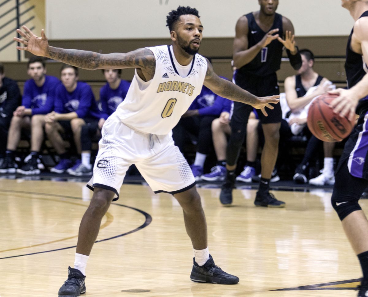 Brian Morton, senior guard, plays defense at the Jan. 28 game at White Auditorium. Morton reunited with his brothers whom he was separated from at a young age and is raising a daughter while attending ESU.