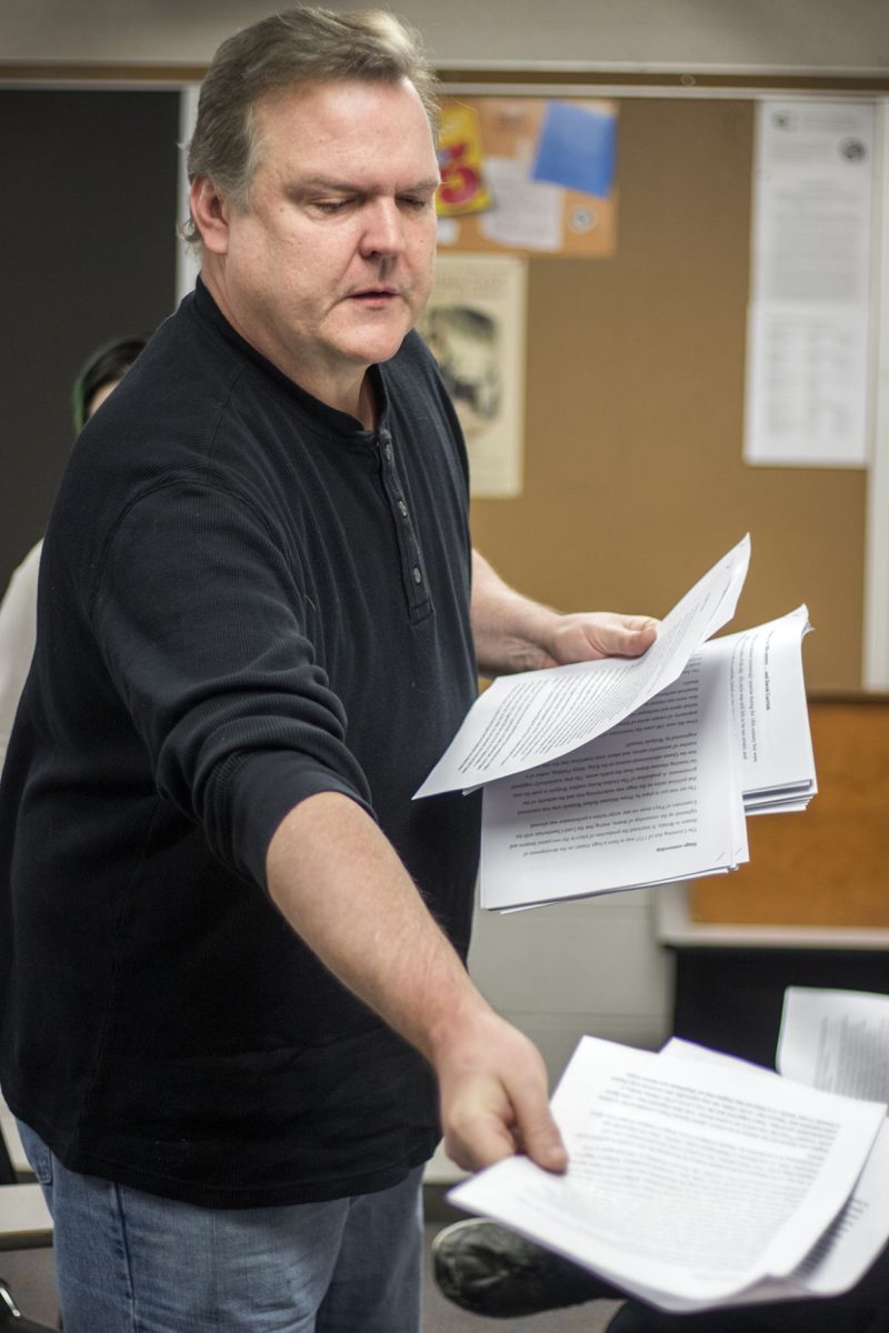 Robert Hart, theater instructor, hands out papers to groups of students in History of the Theater II yesterday in King Hall. Hart spent two weeks of Winter break at Zheijiang Normal University in Jinhua, China teaching four different drama and theater classes.