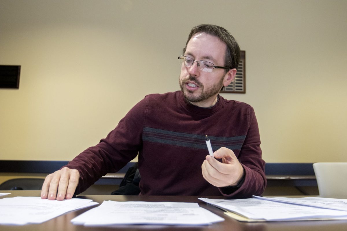 Chad Wiley, associate professor in mathematics and economics, looks through the Stanford&#160;consensual relationships policy during the faculty affairs meeting on Tuesday in Roe R. Cross room. KBOR is looking to implement a policy and wanted faculty input from all regent universities.