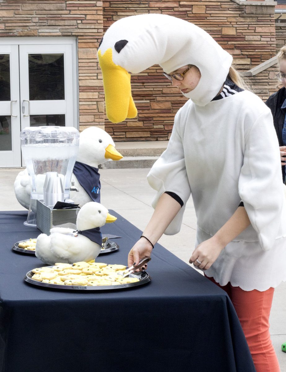 Bobbi Rookstool, freshman English education major, wears a duck costume and takes a duck shaped cookie during the event welcoming back the ducks by Wooster Lake. At the event, songs about ducks played and Kathryn Jackson, freshman pre-med major and creator of the ESU Ducks social media pages, spoke to the participates.