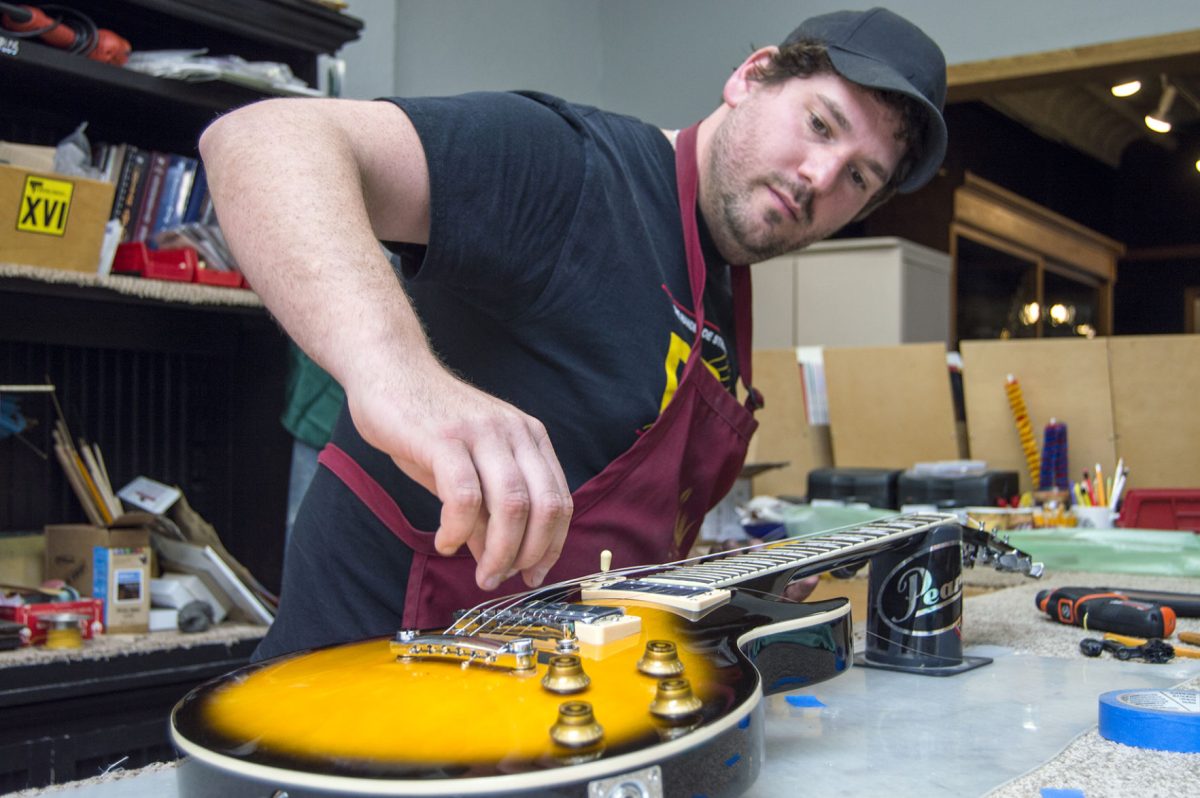 Thomas Silkman, owner of Flint Hills Music, practices for his attempt to break the world record for stringing the most guitars within an hour on Tuesday in the Flint Hills Music store. Silkman will attempt to beat the record of 183 strings, or about 31.5 guitars in an hour 5 p.m. on Friday in the Flint Hills Music store.&#160;