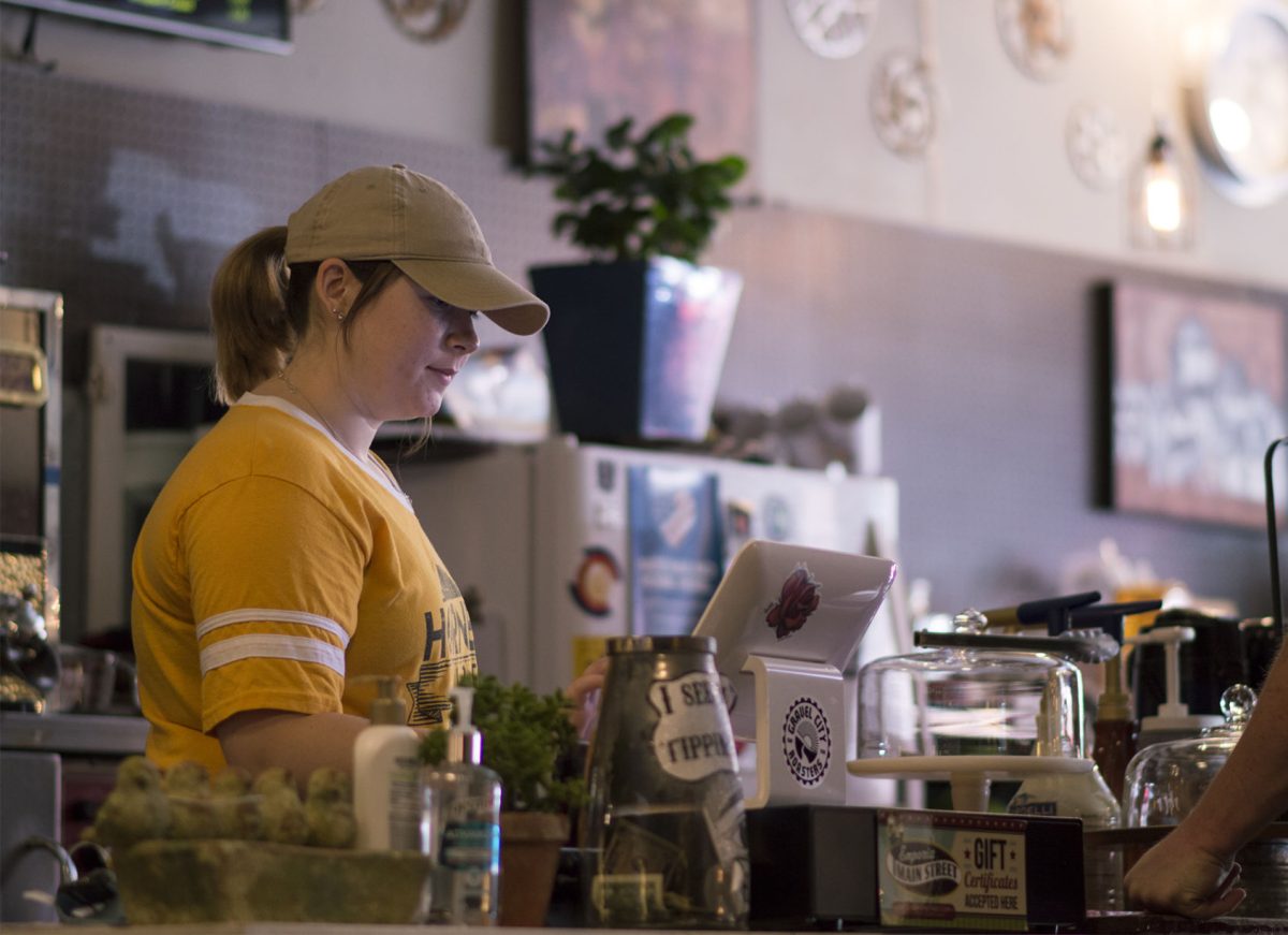Lucy Baker, barista at Gravel City Roasters, 608 Commercial St. and freshman undecided major, checks out a customer. There are many fall events to participate in Emporia, including trying season drinks at local coffee shops.