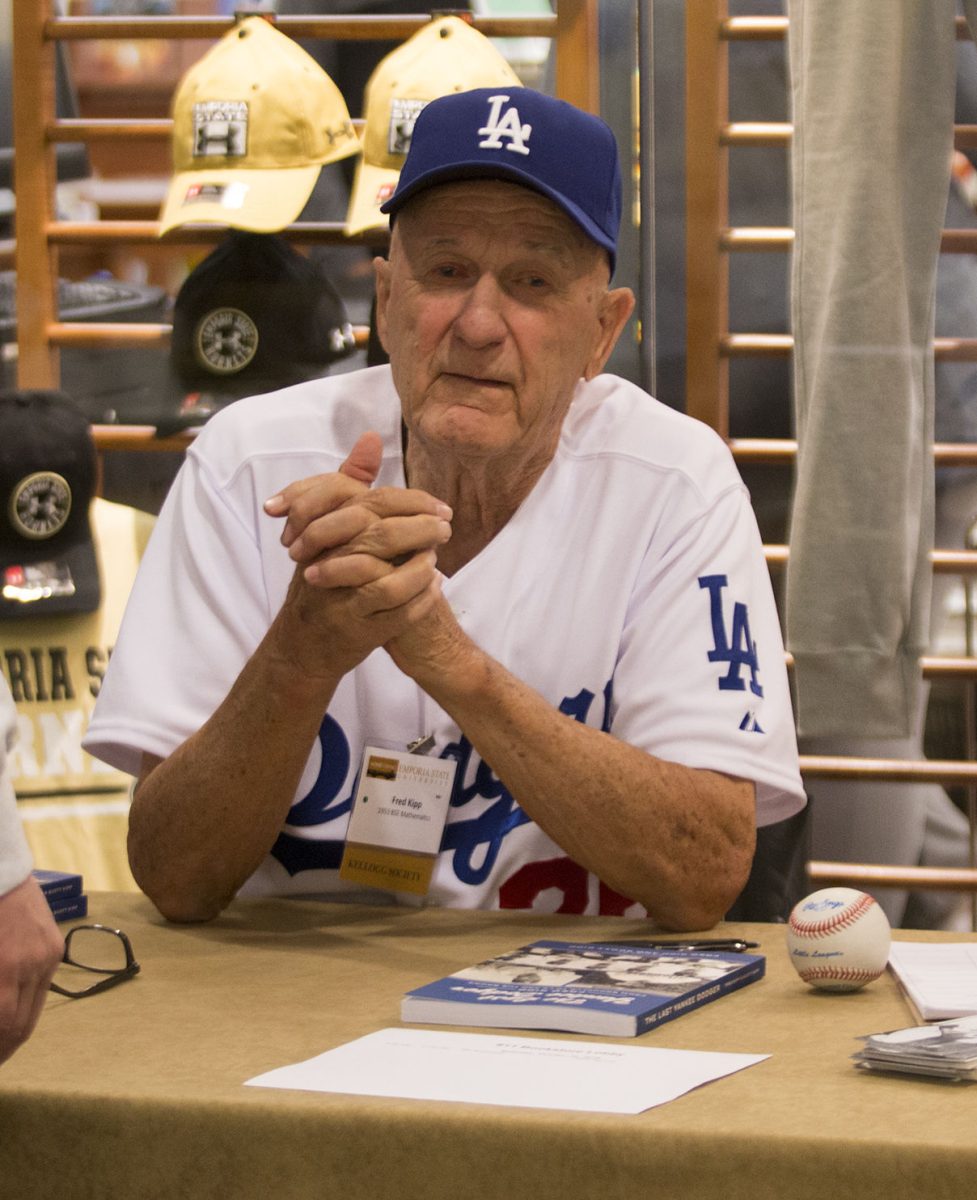 Sitting next to his wife, Lorraine Kipp, Fred Kipp signs books for fellow Emporia State alumni. Fred Kipp&#8217;s book, &#8220;The Last Yankee Dodger,&#8221; came out in January.