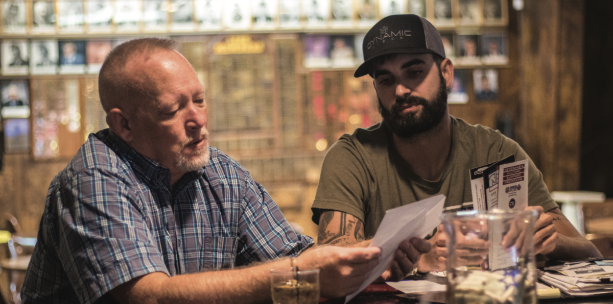 Michael White, commander of VFW Post 1980, 932 Graphic Arts Rd., and junior political science major, talks with Gerald Kehres, trustee and former commander, about KC Relon, a regional student veteran conference.