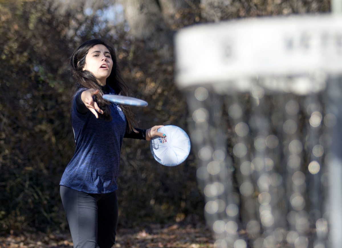 Paige Bjerkaas, junior elementary education major, demonstrates how to putt yesterday at Peter Pan Park. Bjerkaas, who started disc golf when she was 10, won the Professional Disc Golf Association World Championship in September.&#160;