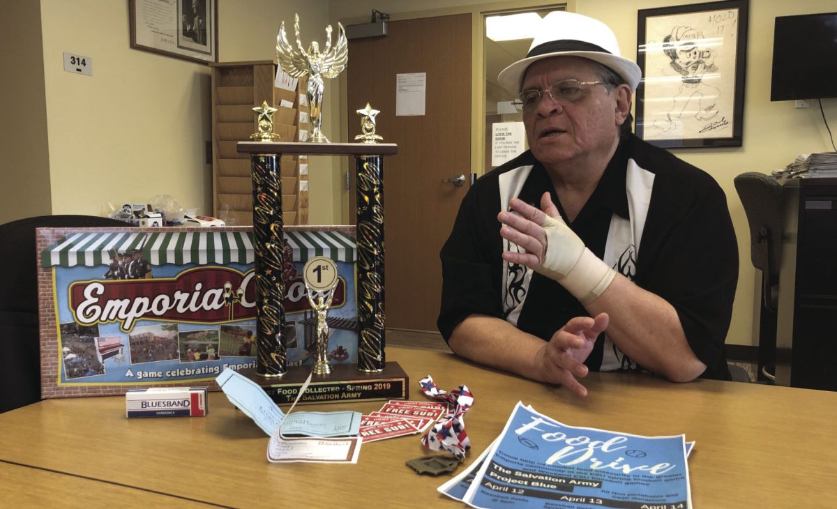 Lorenzo Tuero, freshman communication major, talks about his group's partnered three day food drive with The Salvation Army. He sits nexts to the raffle prizes which were donated by six local businesses, including Emporia Main Street, Flint Hills Music, Casa Ramos, Sweet Granada, Jimmy Johns and Complete Works Custom Engraving.