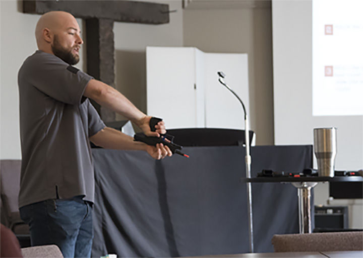 Skylar Delmont, Certified Conceal Carry Administration trainer, demonstrates how to safely disassemble a handgun on Sept. 14, at the Twelfth Avenue Baptist Church. Teaching the class how to safely demonstrate tasks, such as this was a top priority before going to the shooting range later in the class.&#160;&#160;