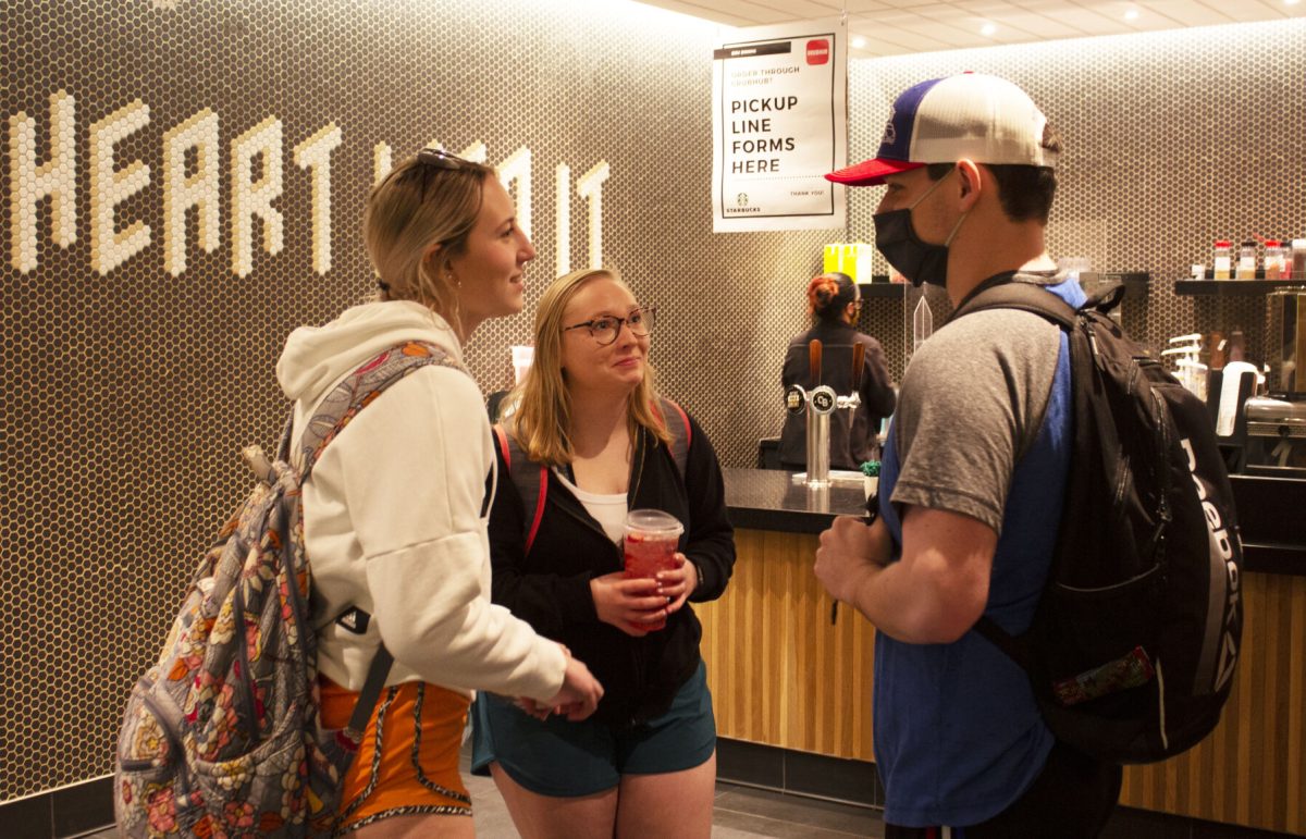 Freshman elementary education majors Autumn Fitzgeralds and Ashtian Canfield talk with freshman business major Benny Bolen while waiting for their Starbucks order on Tuesday in the Memorial Union. The mask mandate was lifted on Tuesday, March 1, however professors are still allowed to require masks in their classes.