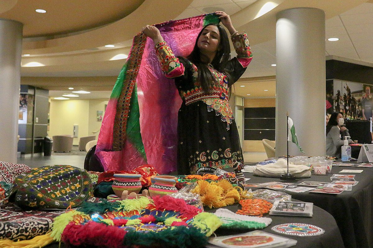 Sahra Iqbal, junior elementary education major, stands at the Pakistani table during the Emporia State Culture Caf&#233; held in the Memorial Union on Monday, March 28. The table displayed the country&#8217;s cultures and artifacts with clothes, jewelry and other everyday items.