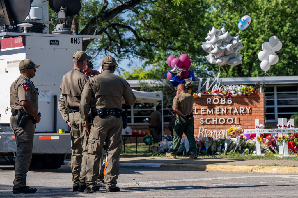 UVALDE, TEXAS - MAY 26: Law enforcement officers stand near a memorial at Robb Elementary School following a mass shooting on May 26, 2022 in Uvalde, Texas. According to reports, 19 students and 2 adults were killed, with the gunman fatally shot by law enforcement. (Photo by Brandon Bell/Getty Images)