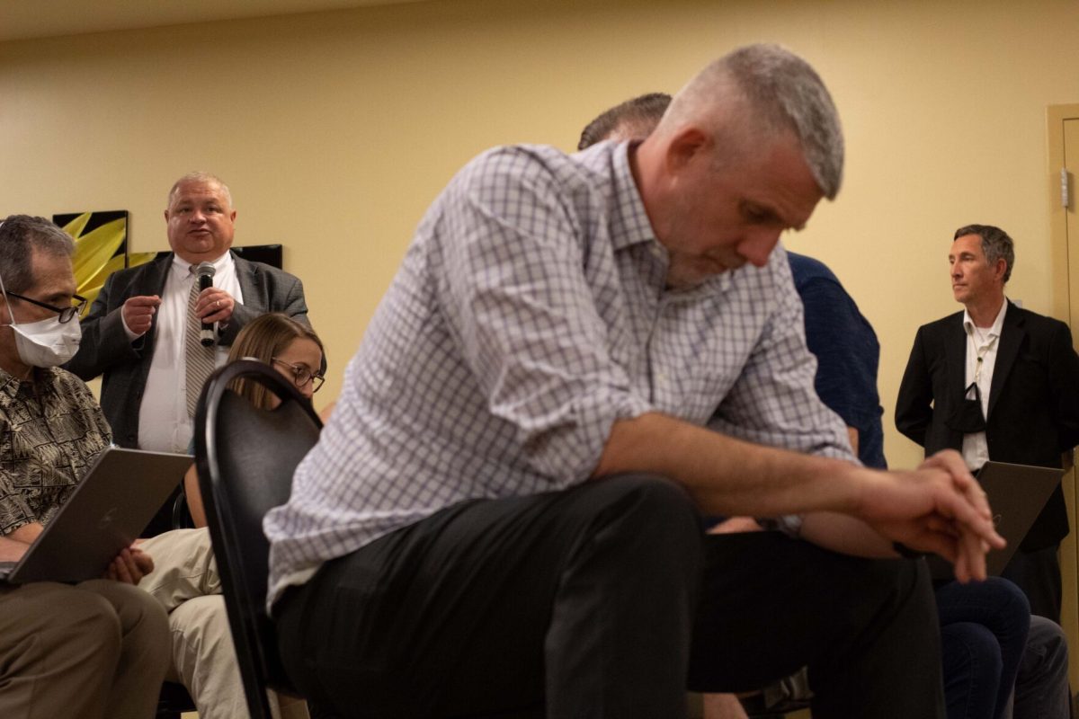 Dan Colson, associate professor of English, modern languages, and journalism, sits with his head hanging while interim provost Brent Thomas answers questions from faculty members during Friday's meeting. (photo by Sam Bailey)