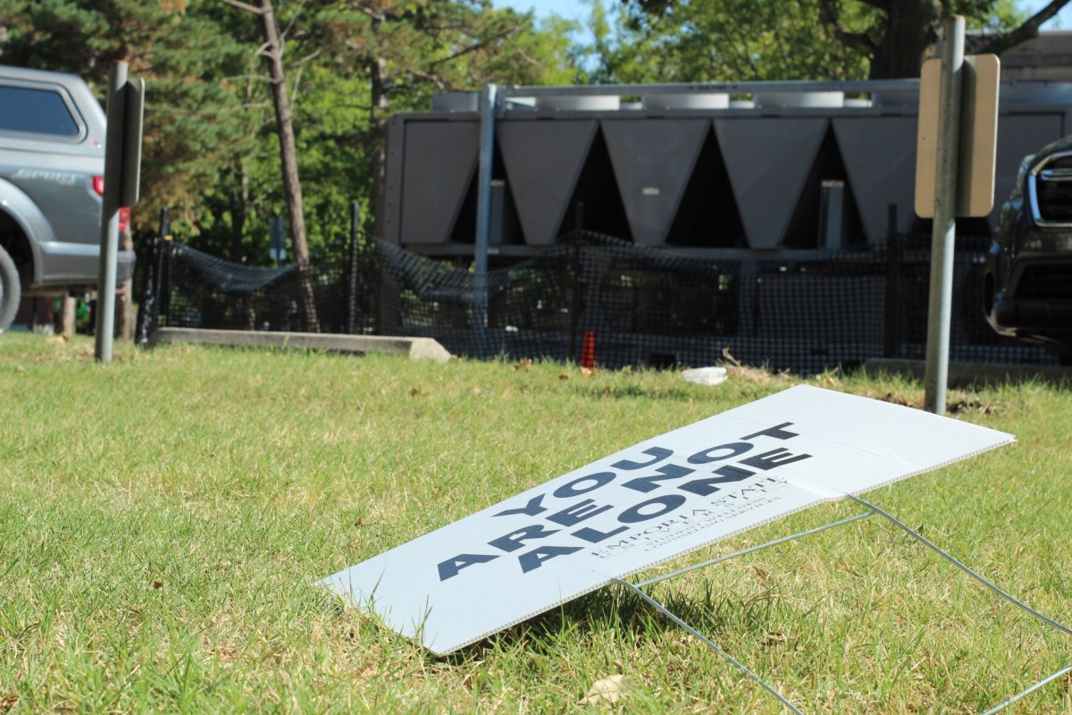 A "You are not alone" sign lays fallen on the ground in front of administration's parked cars. President Hush's parking spot sits empty while a faculty senate meeting to plan an open forum to allow faculty to voice their concerns around new university framework begins Sept. 8. (photo by Sam Bailey)