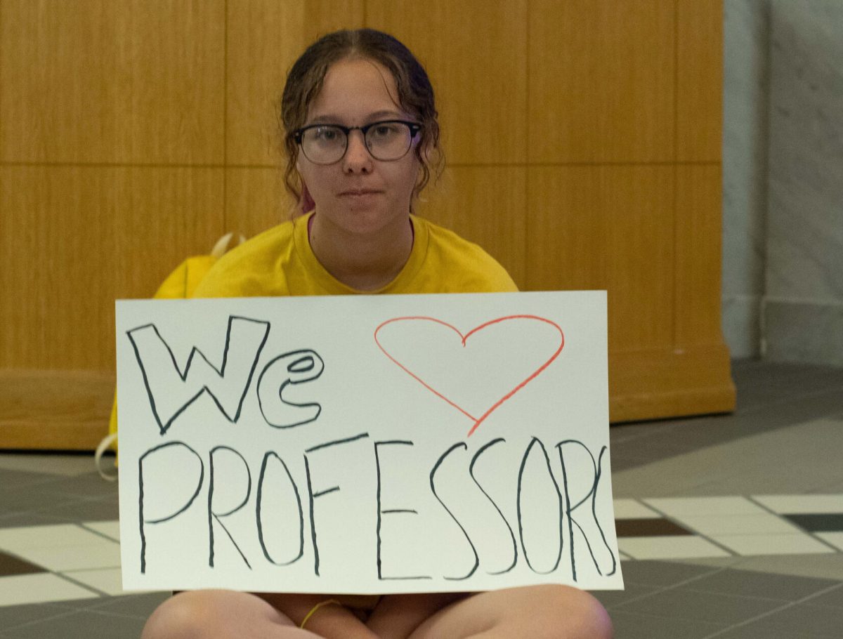 Alyssa Gharmalkar, junior history major, protests Friday on the first floor of Plumb Hall. Students organized a silent sit-in below the president's office to show their support for the 33 faculty who were dismissed at Emporia State. (photo by Sam Bailey)