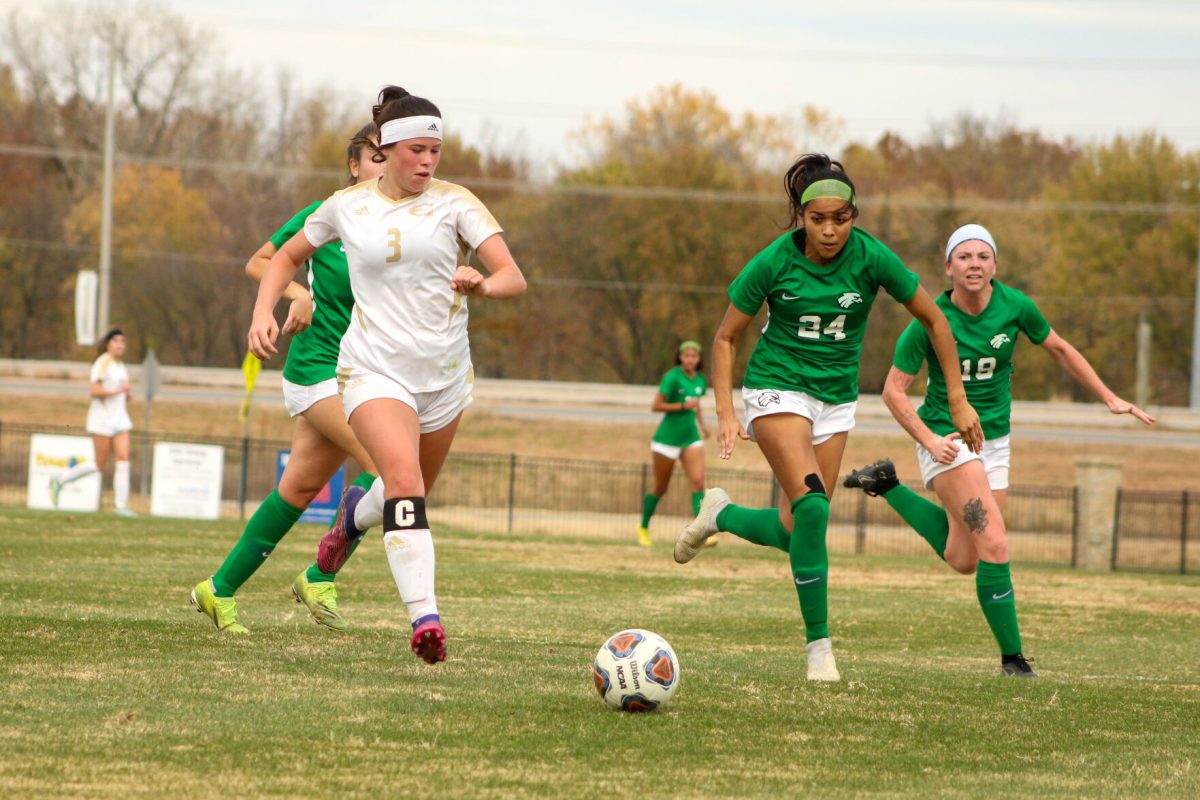 Forward Mackenzie Dimarco dribbles the ball downfield past multiple Northeastern defenders.