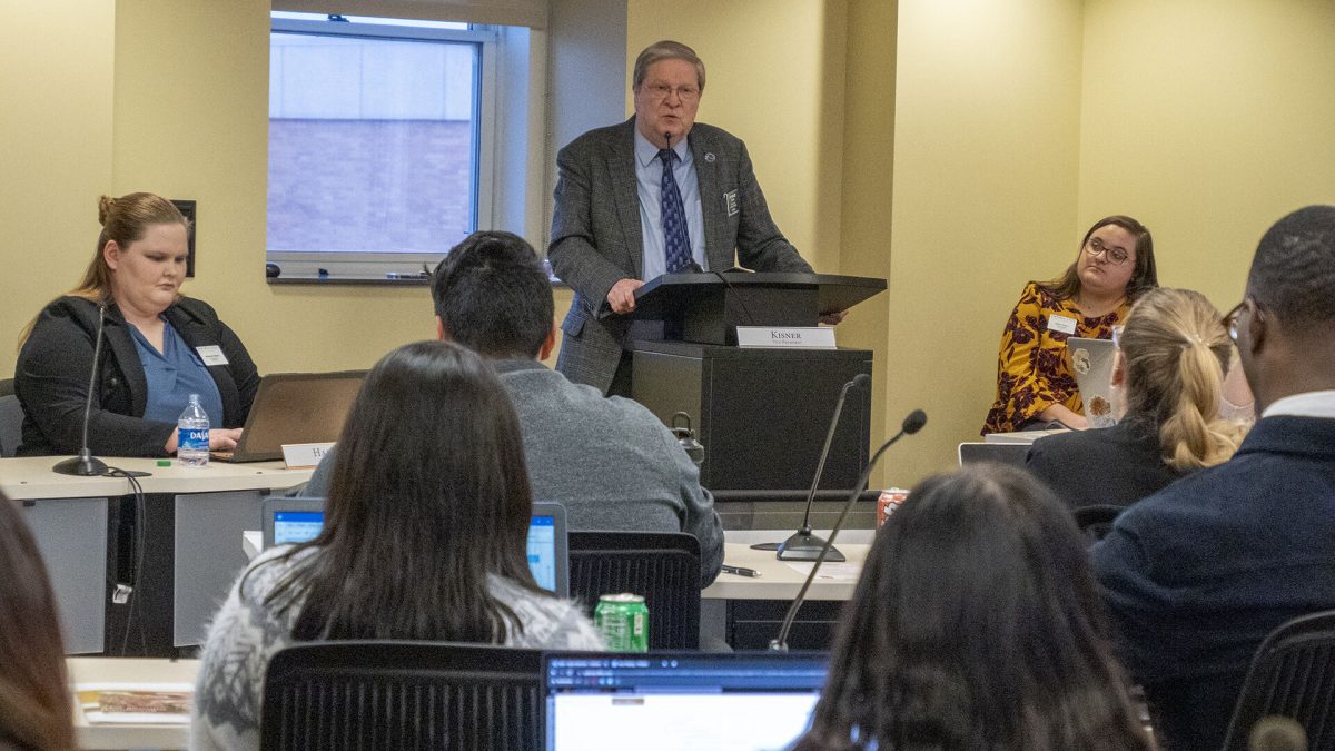 House Minority Leader Vic Miller, an Emporia State University graduate, addresses the student government during a Jan. 26, 2023, meeting at ESU. The framed poster is from his successful run for student president in the early 1970s. (Sherman Smith/Kansas Reflector)&#160;