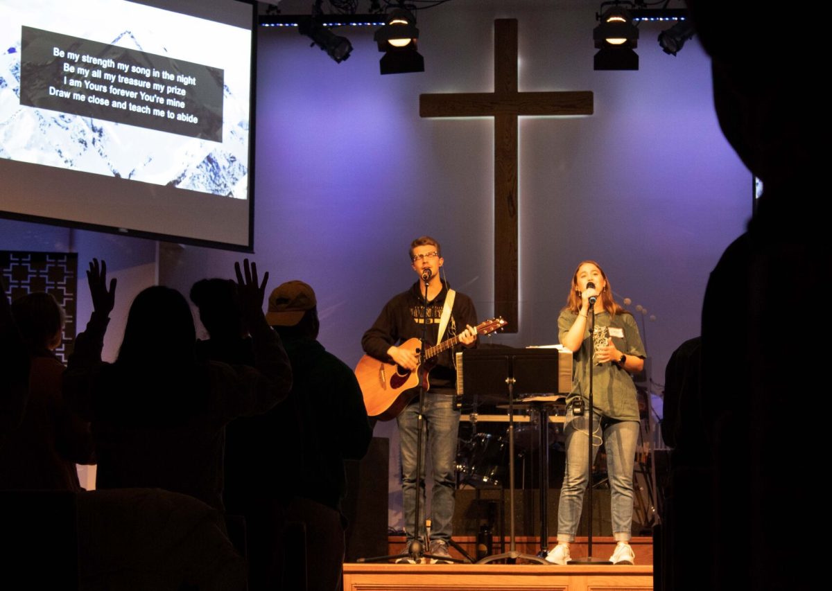 Jack Jewett, a senior studying English and creative writing, and Katie Webb, junior pre-physical therapy health and human performance major, sing &#8220;Abide&#8221; by Dwell Songs while a student in the crowd raises their hands in praise. The song was part of the worship during Christian Challenge&#8217;s Thursday meeting during its &#8220;Arguments against Christianity&#8221; series.