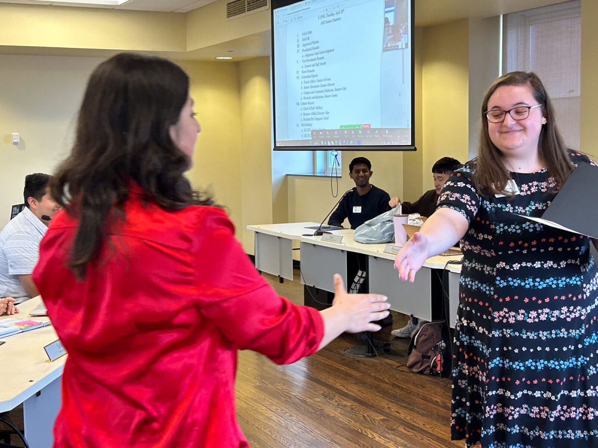 ASG vice president Hailey Kisner awards junior political science major Hibah Yaseen with &#8220;most likely to be late to a meeting.&#8221;
