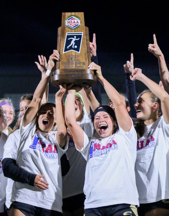 (left) Midfielder Hannah Wooley and (right) foward Mackenzie Dimarco and
the rest of the ESU womens soccer team hoist the 2023 MIAA tournament
trophy after winning the championship game against Central Missouri.