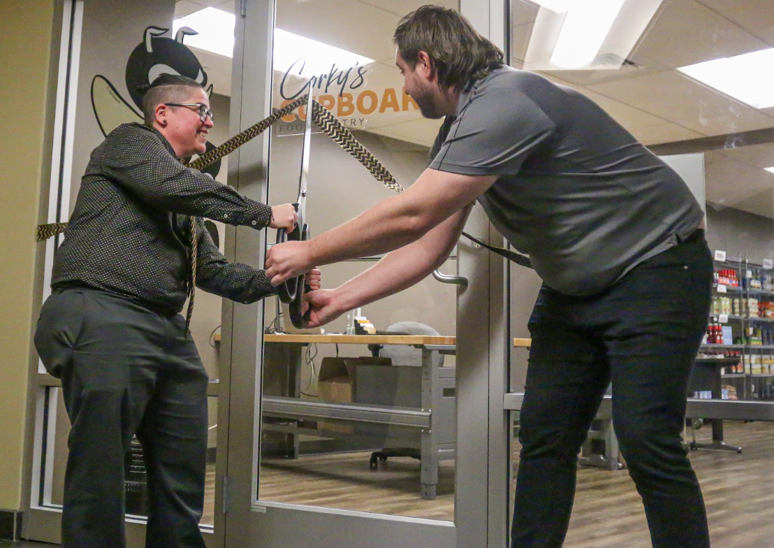 Nyk Robertson, Senior Diversity Officer and Assistant Dean (Left), and Cale Bolen, Basic Needs Coordinator (Right) are seen cutting the grand opening ribbon of Corkys Cupboard on Feb. 16.