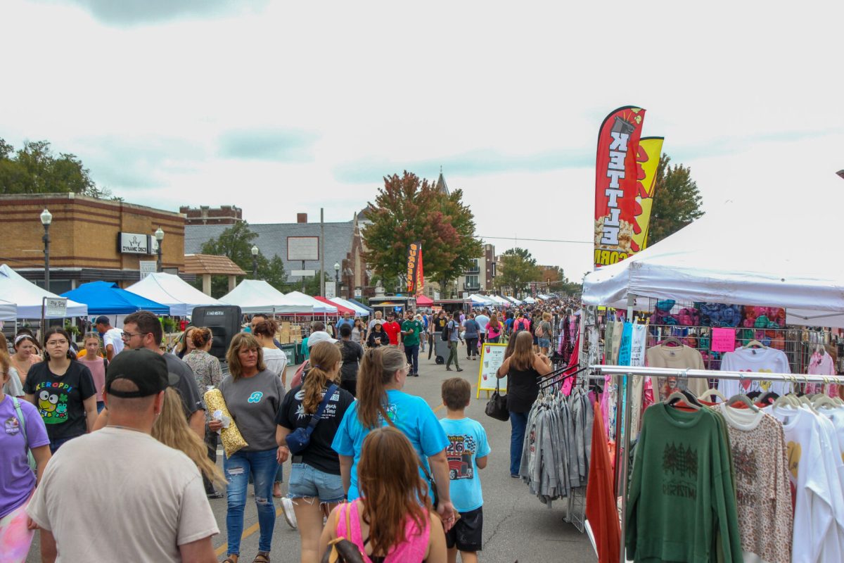 A crowd walks down Commercial St. while vendors are set up on both sides of the road.