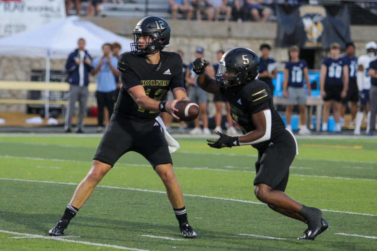Junior quarterback Gunnar Gundy hands the ball off to graduate student running back Billy Ross Jr., nearing the end of the second quarter against the Washburn Ichabods.&#160;