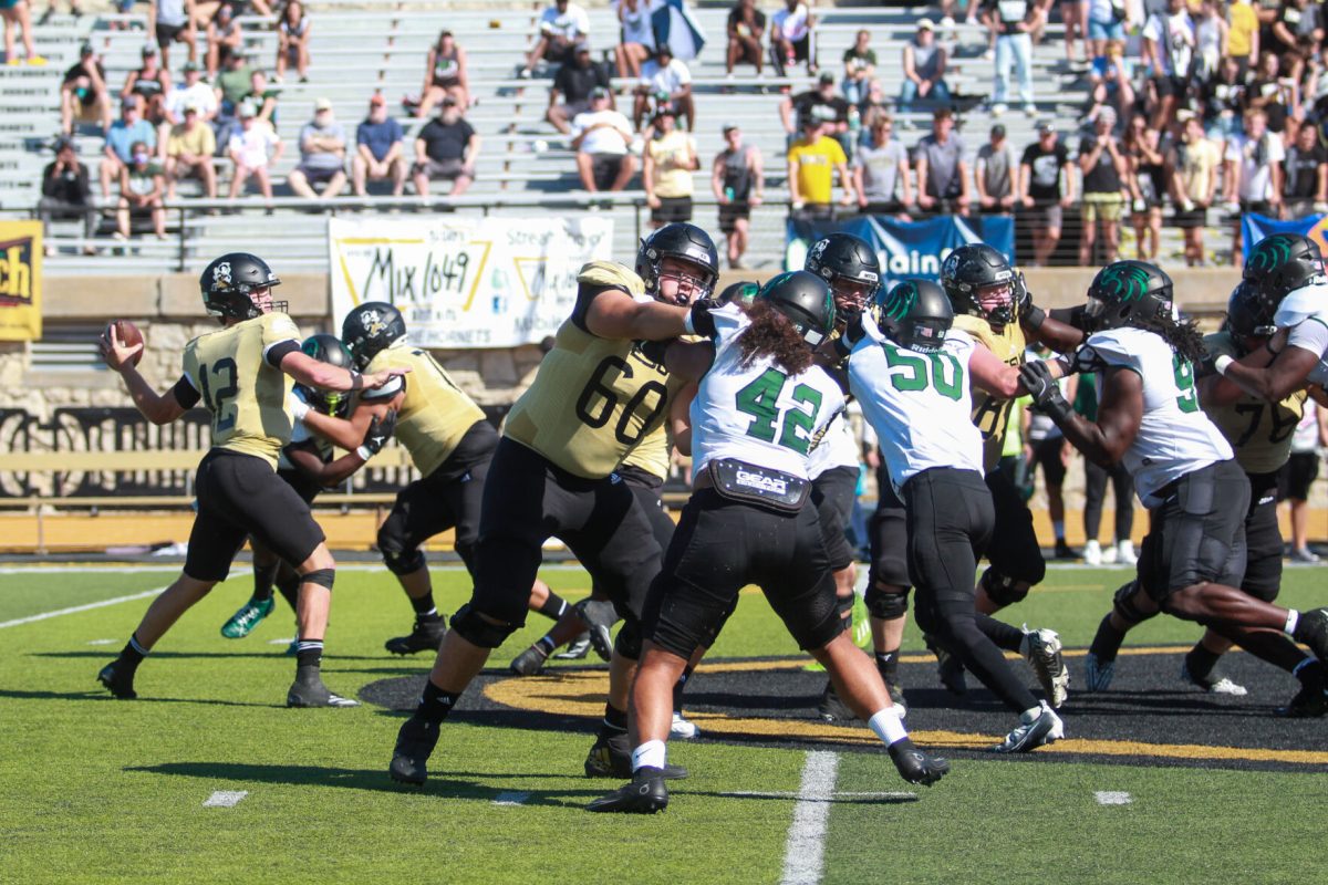 Junior quarterback Gunnar Gundy makes a pass while the ESU offensive line holds off the NSU line.