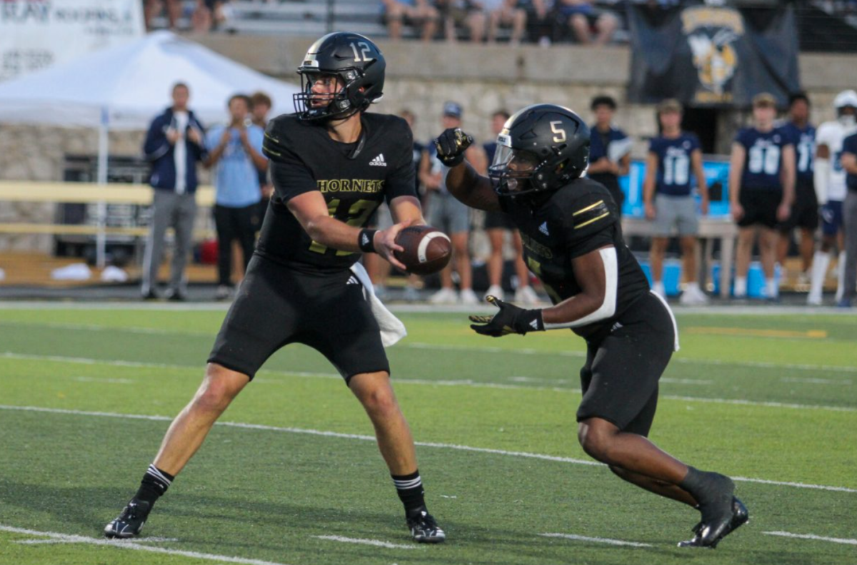 Former junior quarterback Gunnar Gundy hands the ball off to graduate student running back Billy Ross Jr. at the 2024 season opener on Aug. 29 against the Washburn Ichabods. 