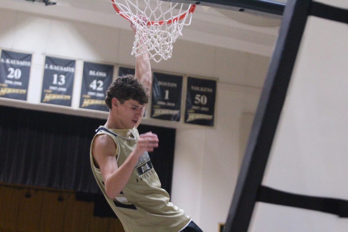 Sophomore forward Chris Harris  hangs from the rim of the basketball hoop after dunking the ball during a team scrimmage at Late Night at White on Nov. 5, 2025. Harris helped move the Hornets to an 84-71 win against Northeastern State Thursday with a buzzer-beating basket in a road game against the Riverhawks. 